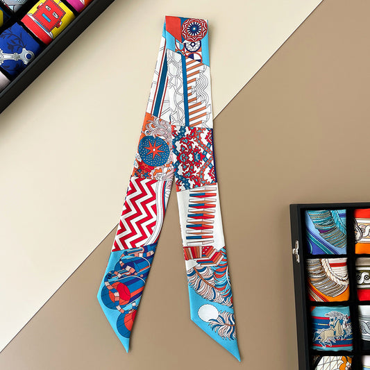 A selection of colorful silk hair ties in a variety of patterns, displayed on a flat surface with a drawer of pattern designs in the background.